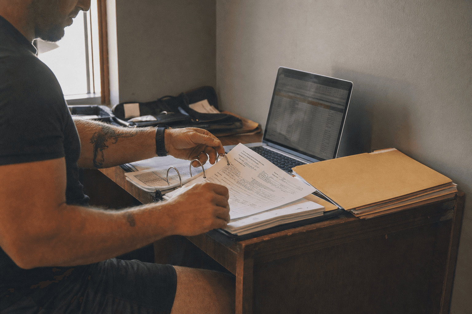 A personal trainer filing a signed client form into a binder of records