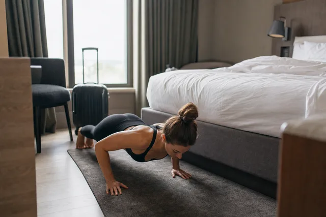 A woman doing a push-up in a hotel room